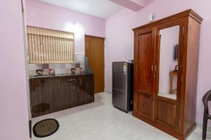 a kitchen with a refrigerator and a wooden cabinet at The Lobos in Madgaon