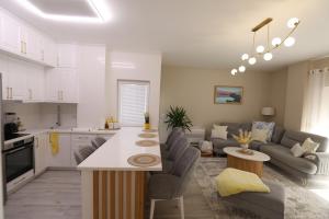 a kitchen and a living room with a couch and a table at Lakeside Serenity Apartment in Pogradec