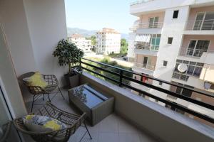 a balcony with chairs and a view of a city at Lakeside Serenity Apartment in Pogradec