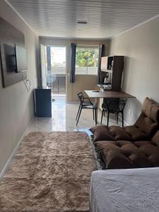 a living room with a couch and a dining room table at Apartamento Moderno Novo 2025 in Passo Fundo