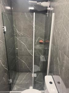 a bathroom with a glass shower with a toilet at Apartamento Moderno Novo 2025 in Passo Fundo +8 photos