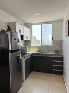 a kitchen with a stainless steel refrigerator and a sink at Suite en Salinas con Vista al Mar in Salinas