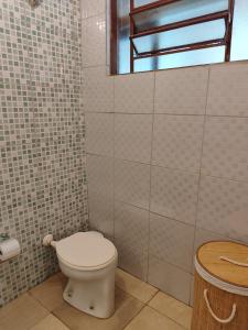 a bathroom with a toilet and a tiled wall at Kascata Complexo de Refúgio in Conceição dos Ouros +34 photos
