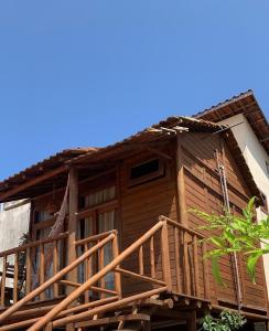 a wooden house with a deck on the side of it at Chalé do beco,flecheiras in Trairi