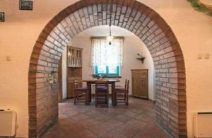 a brick archway in a dining room with a table at Ferienhaus In Radići Mit Privatem Pool in Jakići