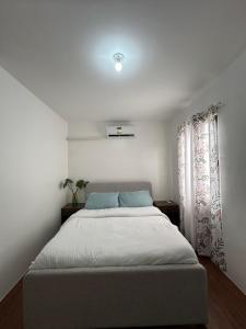 a bedroom with a bed and a window at Almond drive 2BR Townhouse Near SRP Nustar Talisay in Talisay