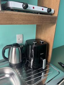 a tea pot sitting on top of a stove at Flats e Residence - Apartamento novo in Passo Fundo