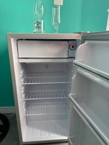 an empty refrigerator with its door open with a wine glass at Flats e Residence - Apartamento novo in Passo Fundo