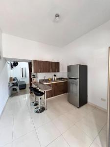 a kitchen with a table and a refrigerator at Acogedor apartamento en Armenia in Armenia