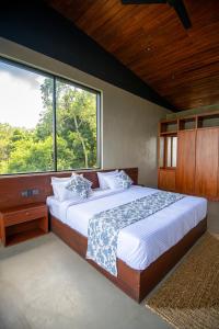 a bedroom with a large bed with a large window at Nuga Retreat- Mindfullness boutique Hotel in Galauda