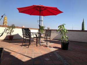 チョルーラにあるDepartamento con Terrazaのパティオ(赤い傘付きのテーブルと椅子付) +4枚の写真