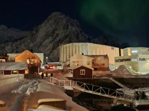 a group of buildings in the snow at night at Kule gule huset in Svolvær