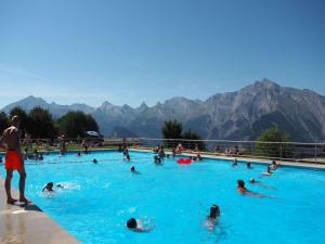 a group of people swimming in a swimming pool at Spacious apartment in Nendaz in Nendaz