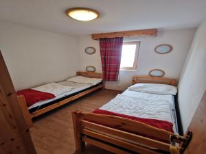 two twin beds in a room with a window at Spacious apartment in Nendaz in Nendaz +22 photos