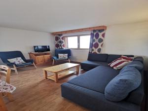 a living room with a blue couch and a table at Spacious apartment in Nendaz in Nendaz