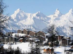 a resort town with snow covered mountains in the background at Spacious apartment in Nendaz in Nendaz