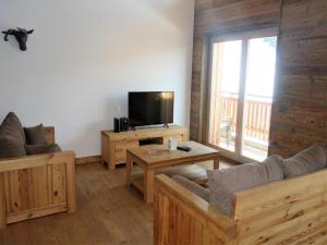 a living room with wooden furniture and a flat screen tv at Duplex apartment in Veysonnaz in Veysonnaz