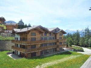 a house on a hill with mountains in the background at Duplex apartment in Veysonnaz in Veysonnaz