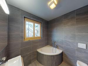 a bathroom with a tub and a window at Duplex apartment in Veysonnaz in Veysonnaz +27 photos