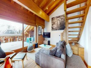 uma sala de estar com um sofá e uma escada em Apartment in central location with views em Nendaz
