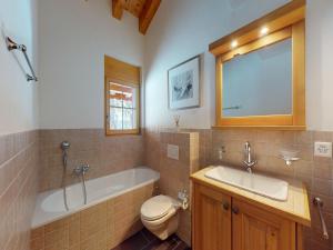 um banheiro com banheira, vaso sanitário e pia em Apartment in central location with views em Nendaz mais 18 fotografias