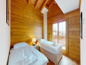 Duas camas num quarto com uma parede de madeira em Apartment in central location with views em Nendaz