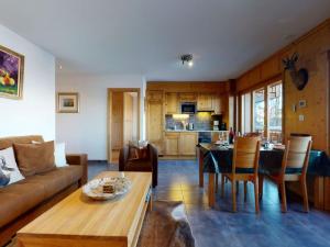 a living room with a couch and a table at Apartment in Veysonnaz with Ski-In Ski-Out in Veysonnaz