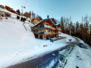a large wooden house on a snow covered mountain at Apartment in Veysonnaz with Ski-In Ski-Out in Veysonnaz