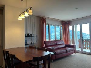 a living room with a table and a couch at Apartment in Veysonnaz with balcony in Veysonnaz