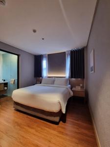 une chambre avec un grand lit dans une pièce dans l'établissement Moonstar Cebu Hotel, à Cebu