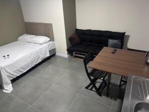 帕苏丰杜Flats & Residences - Apart Moderno com Conforto的配有床、桌子和沙发的房间