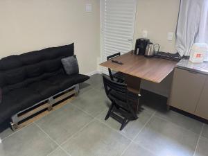 帕苏丰杜Flats & Residences - Apart Moderno com Conforto的一张黑沙发,坐在桌子旁,一张桌子