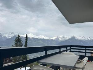 un balcón con una mesa y vistas a las montañas en Charming apartment in Vaysonnaz, en Veysonnaz