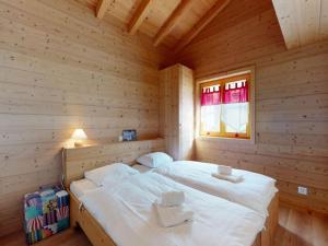 a large bed in a wooden room with a window at Nice apartment with balcony in Nendaz