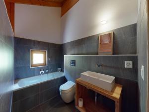 a bathroom with a sink and a toilet and a tub at Nice apartment with balcony in Nendaz +24 photos