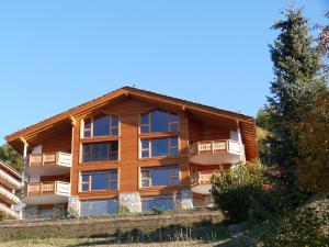 a large apartment building with balconies on a hill at Authentic Apartment With Mountain View in Veysonnaz