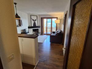 a living room with a kitchen and a living room with a fireplace at Flat in Veysonnaz near Ski Lift & Valley Views in Veysonnaz +15 photos