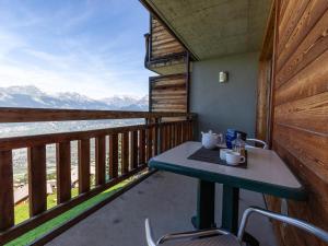 a table on a balcony with a view of the mountains at Nice apartment with valley view in Veysonnaz