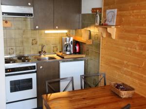a kitchen with a sink and a stove and a table at Studio in Veysonnaz near Ski Lift in Veysonnaz
