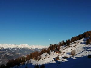 a snow covered mountain with houses on top of it at Studio in Veysonnaz near Ski Lift in Veysonnaz +7 photos