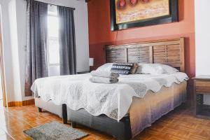 una camera da letto con un letto grande con pareti arancioni di La Ventana del Tepozteco a Tepoztlán