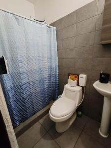 a bathroom with a white toilet and a sink at Apartamento zona 1 in Guatemala