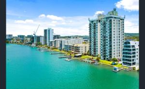a river with boats in a city with tall buildings at Maroochydore Riverfront Apartment in Maroochydore