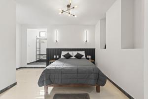 a bedroom with a bed and white walls at Hotel Boutique Árbol de la Vida in Taxco de Alarcón
