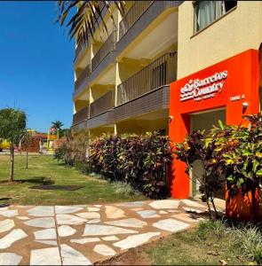 un bâtiment avec un panneau orange sur le côté dans l'établissement Barretos Country Resort - Apto 1 Quarto até 5 Pessoas, à Barretos