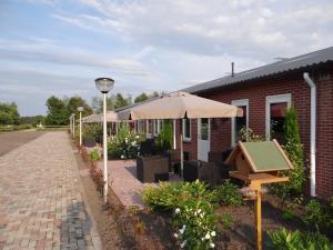 eine Terrasse mit Sonnenschirmen und ein Vogelhaus in der Unterkunft Apartment Nieuw-Moscou in Hollandscheveld