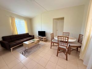 a living room with a couch and a table at Hill Top Cottage in Friar's Bay