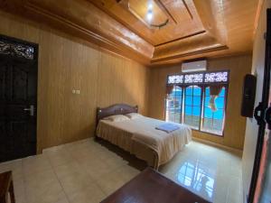 Un dormitorio con una cama y una ventana grande. en Umah Dau Homestay, en Jasri