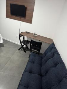 un soggiorno con un divano blu e un tavolo di Flats & Residence - Tu Parada Perfecta Comodidad y Descanso en el Camino BR 285 a Passo Fundo