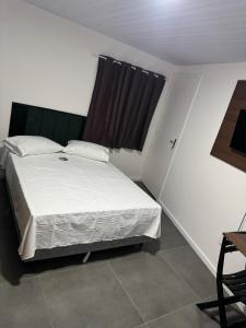 una camera da letto con un letto bianco con una finestra di Flats & Residence - Tu Parada Perfecta Comodidad y Descanso en el Camino BR 285 a Passo Fundo